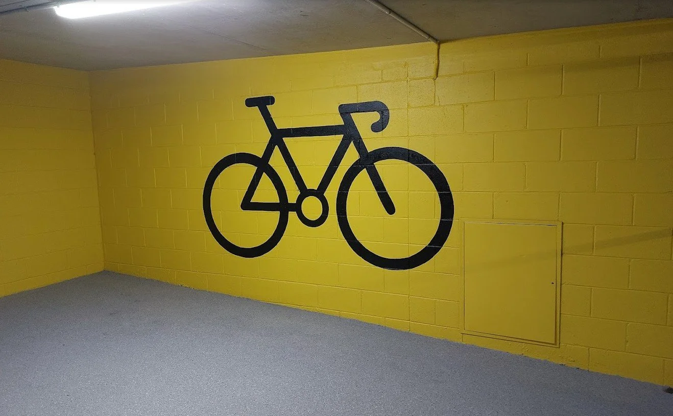 Large hand-painted bicycle wall mural for wayfinding in a corporate end-of-trip facility in Brisbane.