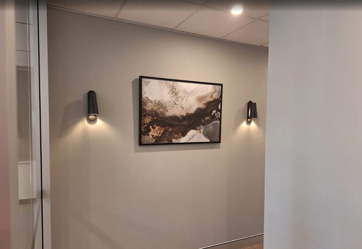 Abstract canvas painting with a custom frame, professionally wall-mounted in a corporate workspace.