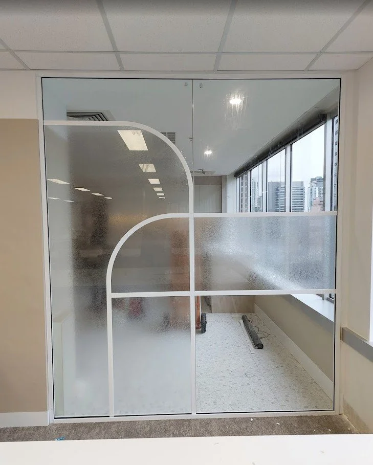 Precision CNC-cut Solyx frosted window film with decorative line patterns for office privacy.