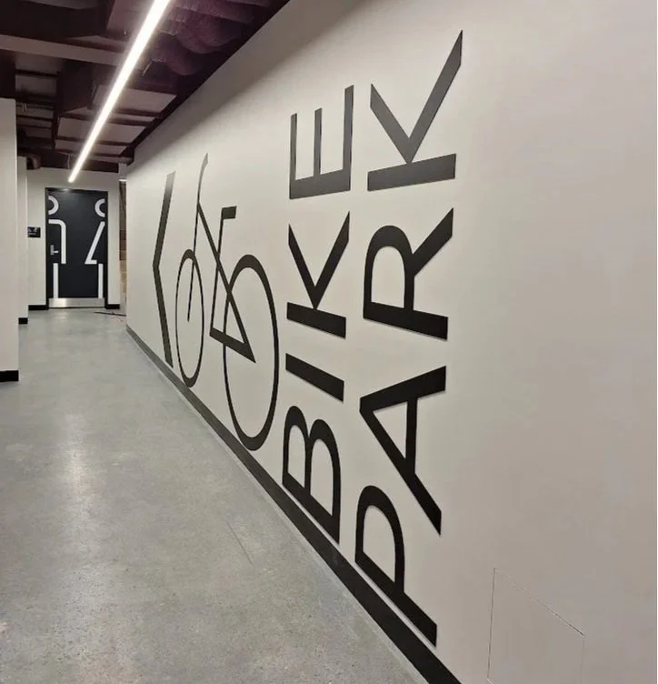Modern directional wall signage and graphics for a corporate end-of-trip bike storage facility.
