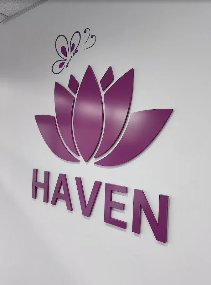 Professional 3D laser-cut acrylic reception sign with purple lotus branding in a Brisbane office lobby.