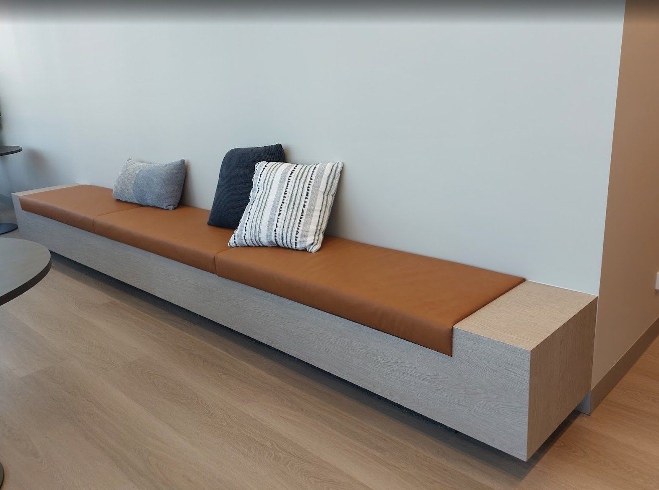 Modern office bench seating refurbished with a durable 3M Di-Noc architectural timber-look furniture wrap.