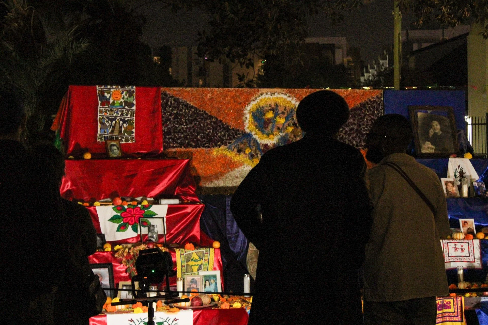 Couple standing in front of a ofrenda during Dia De Los Muertos / Destiny De La Cueva, October 2025