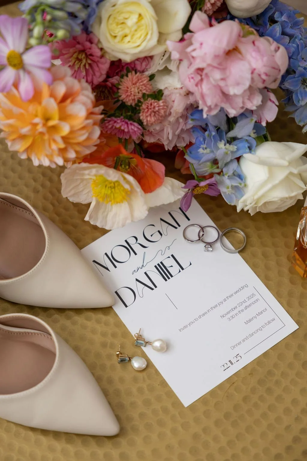 Wedding invitation detailed shot with shoes, rings and bouquet