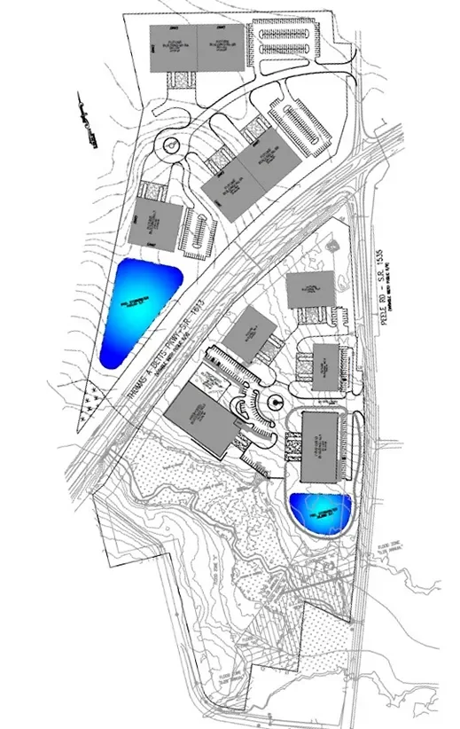 Site plan showing multiple buildings, parking lots, two lakes, and surrounding roads with topographical lines.