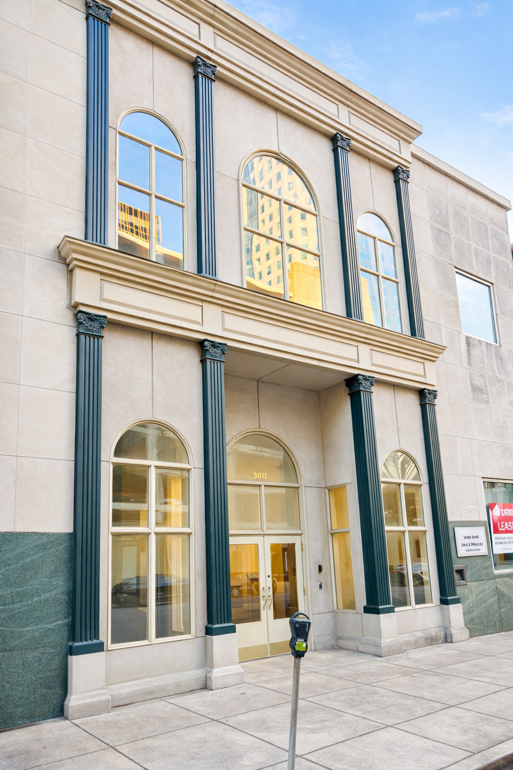 A beige building with tall blue columns and arched windows, reflecting a cityscape with a tall building and blue sky.