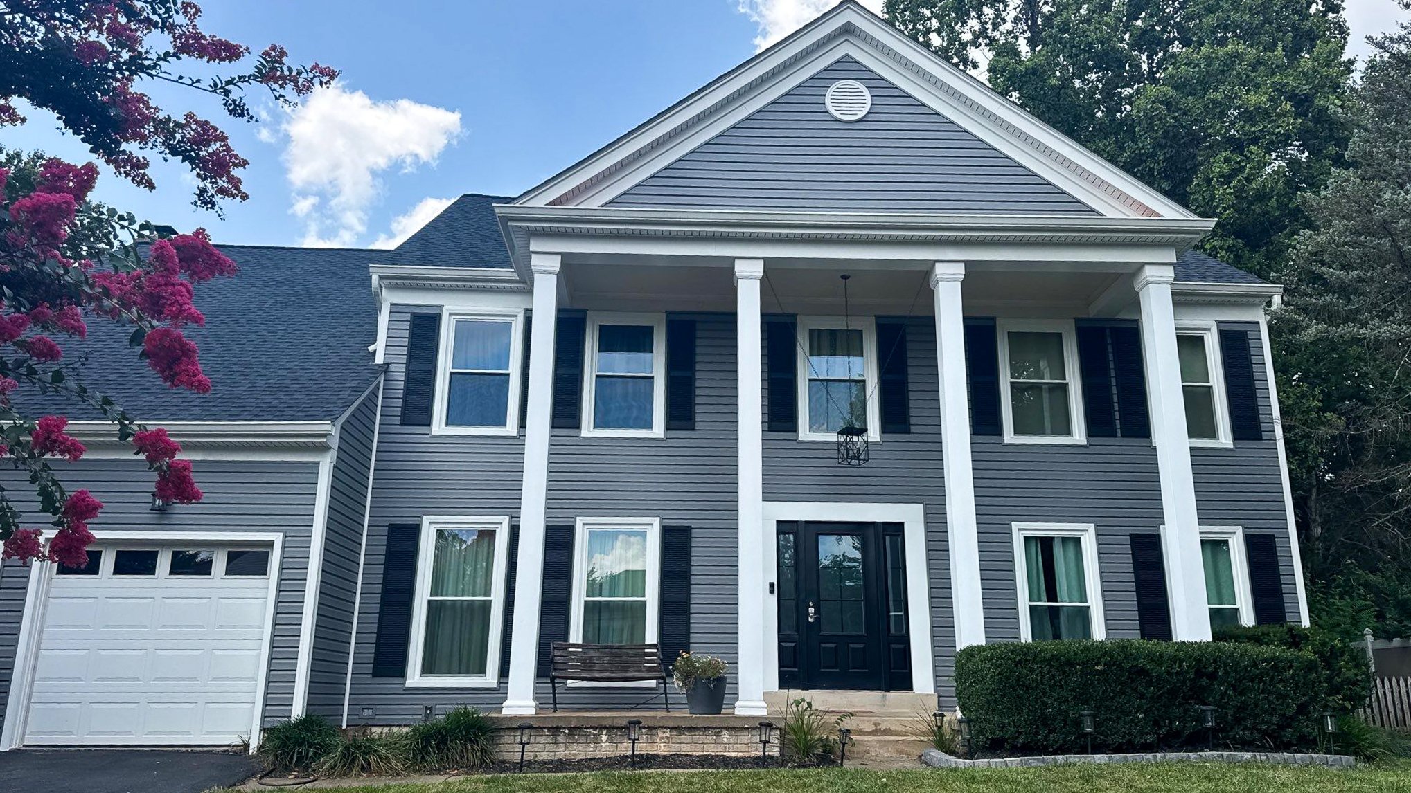 A front view of a house showcasing new siding and a new roof