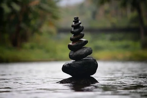 Stack of smooth black stones balanced on water