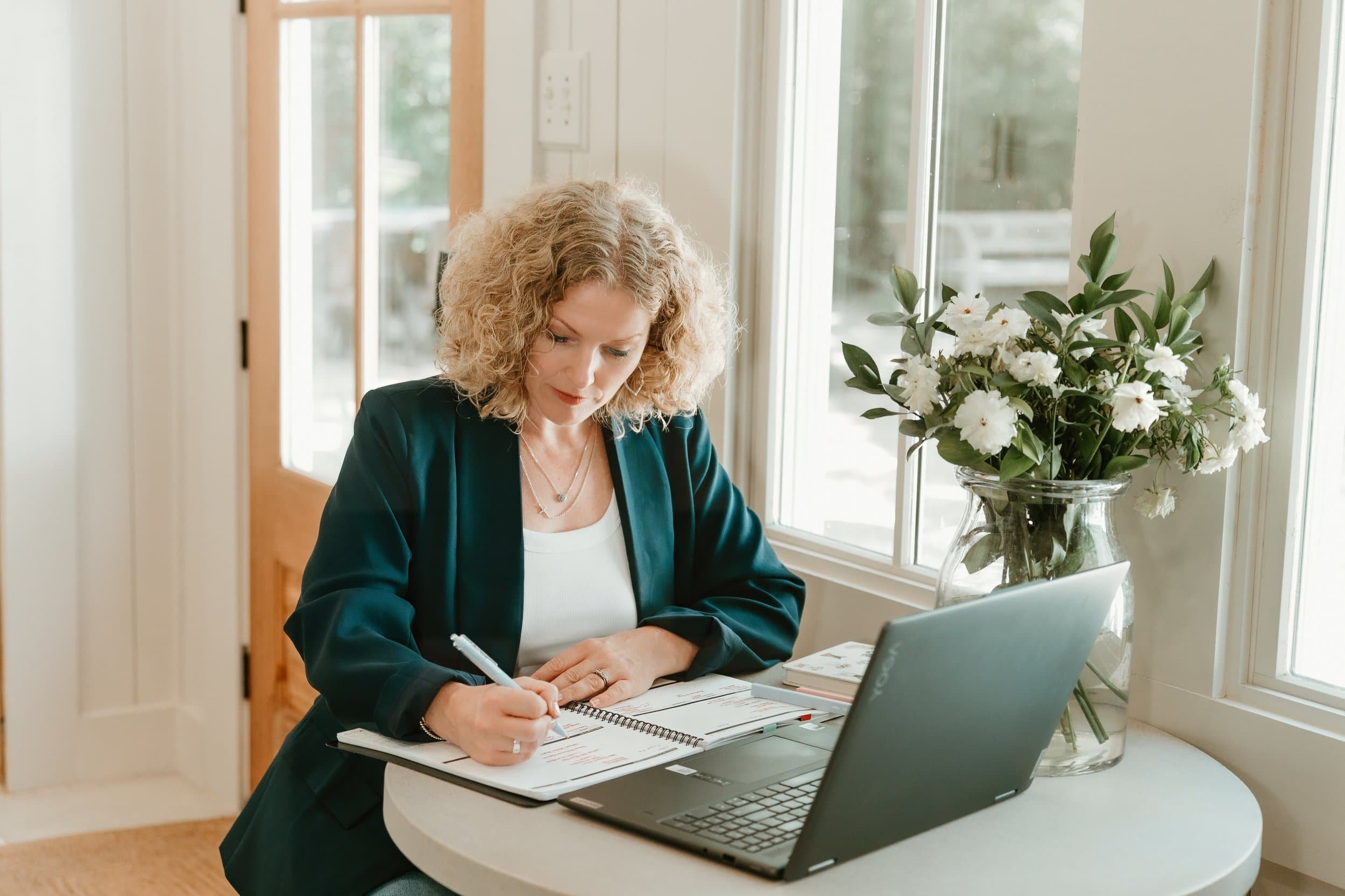 Maggie Roney sitting with a laptop and paperwork at a table