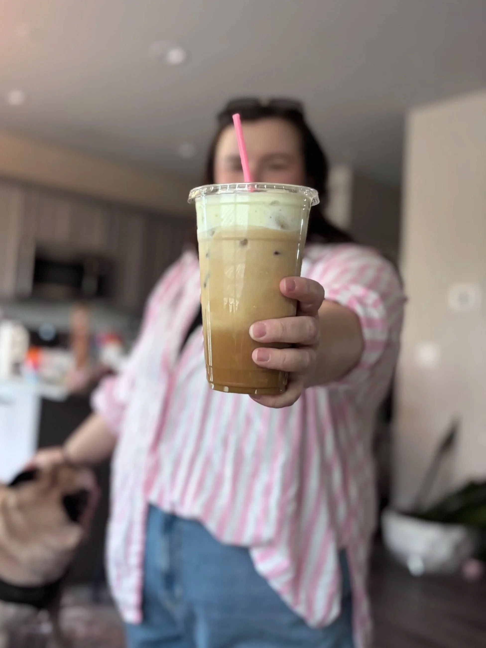 owner of fable coffee cart holding a cold brew latte