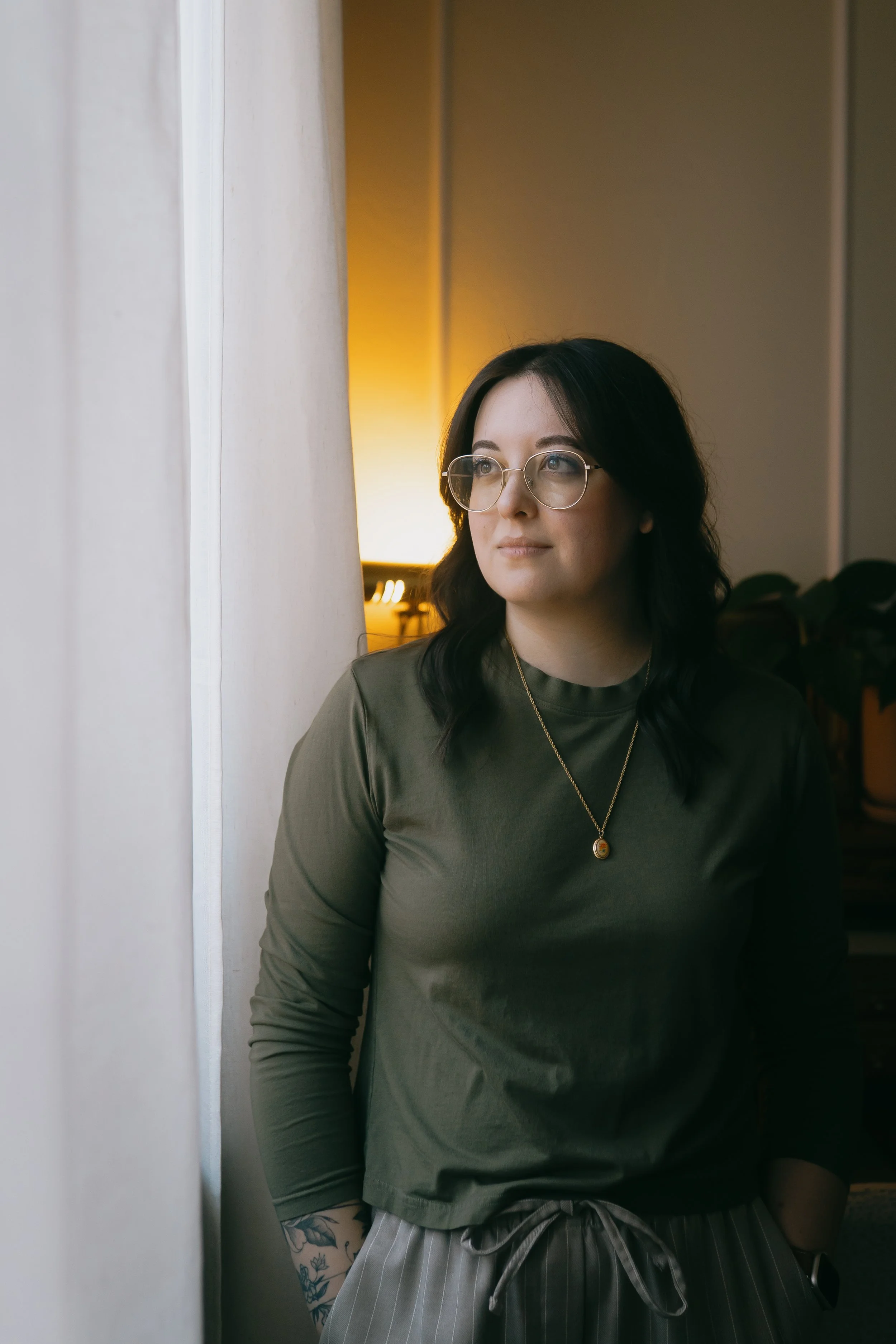 Joanna Jackson, LPC standing next to her office window. She's passionate about working with individuals experiencing anxiety, self-esteem issues, and religious deconstruction.