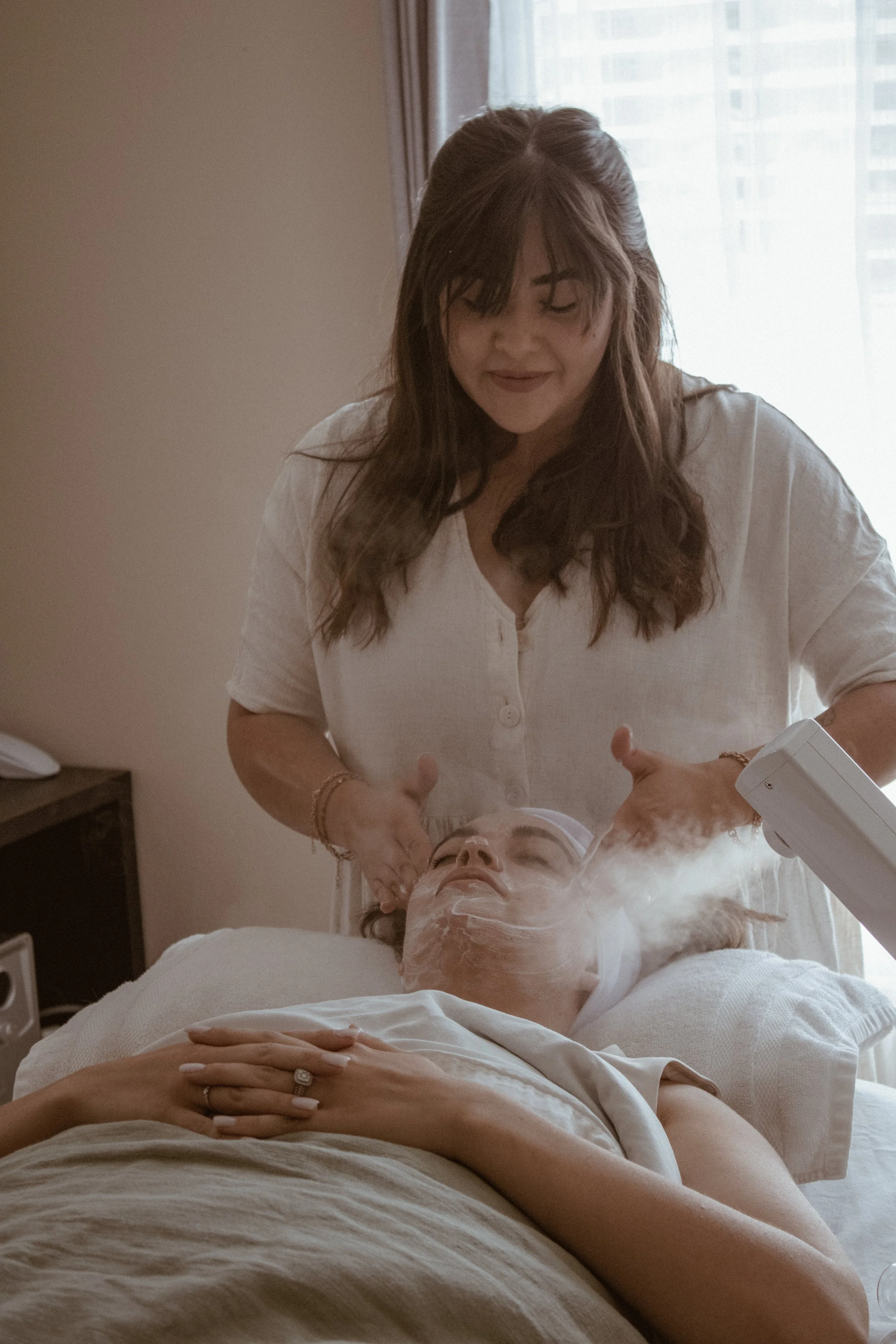 Licensed esthetician performing a customized facial treatment with steam during a relaxing skincare service in Vancouver, Washington
