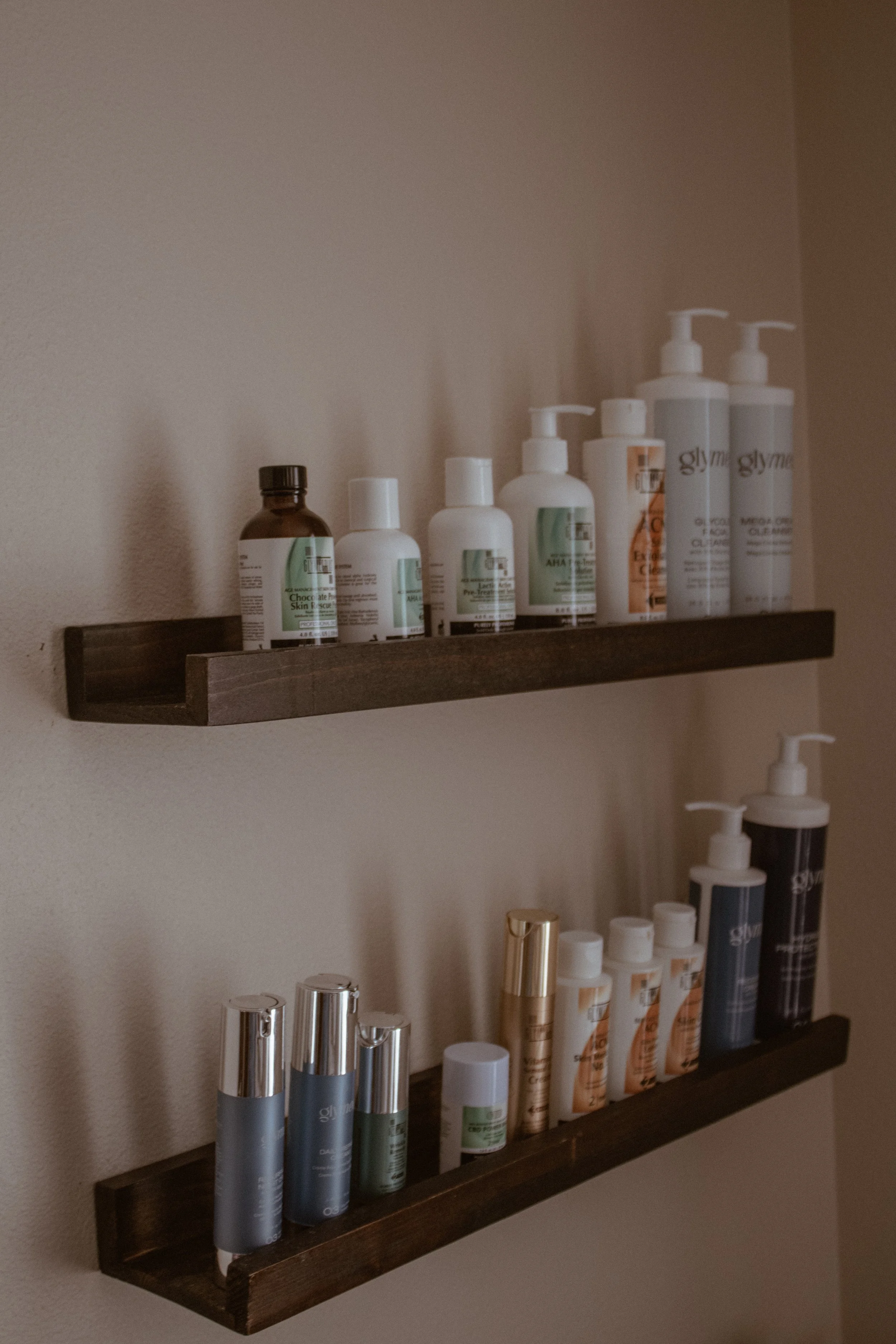 GlyMed Plus professional skincare products displayed on wooden shelves inside the Naked Skin treatment room.