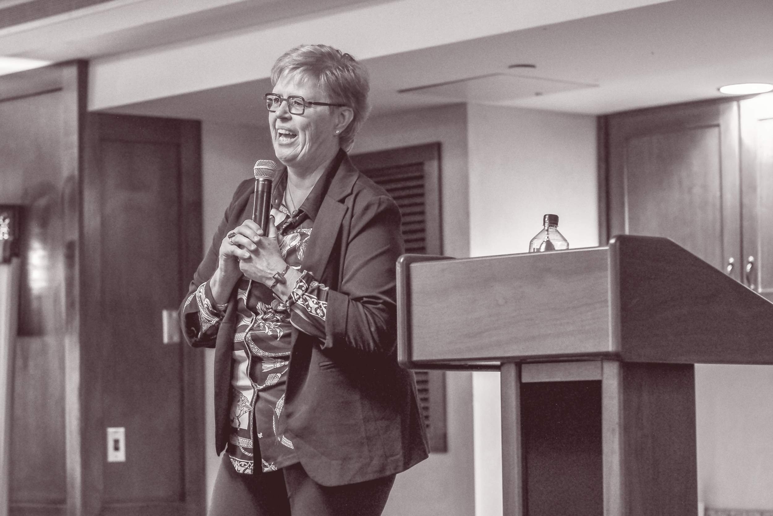  Susan Lynn speaking at a live spiritual conference event with attendees gathered for learning and connection 