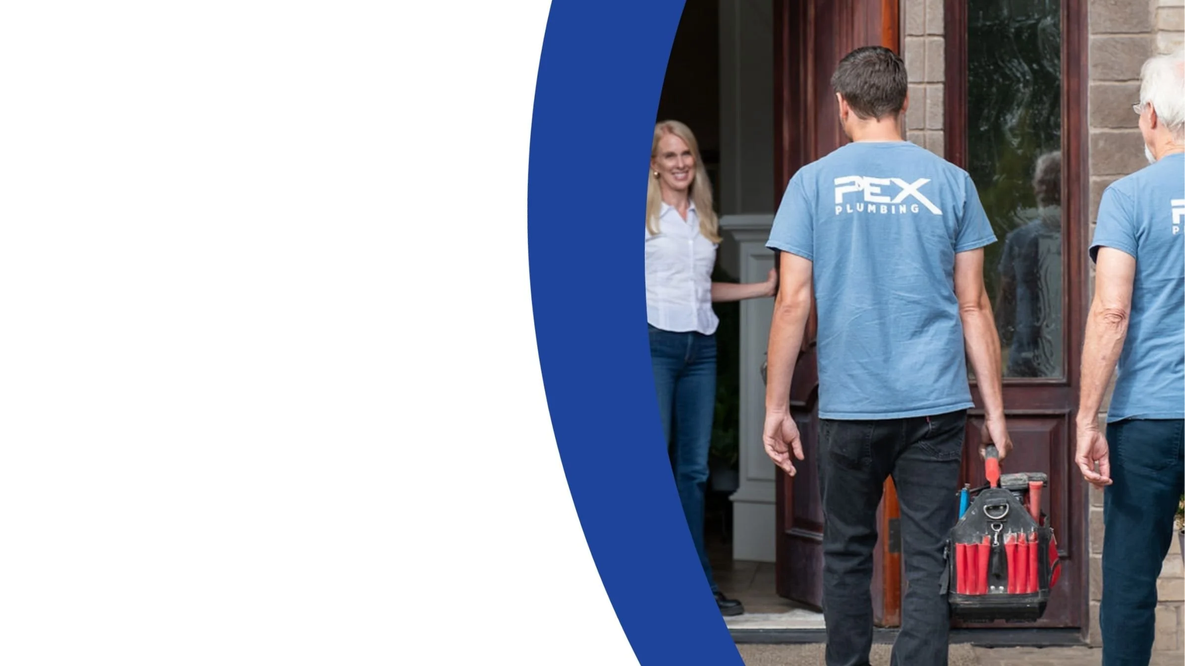 A plumber and an elderly woman standing outside a house, with a woman smiling at the door, holding it open.