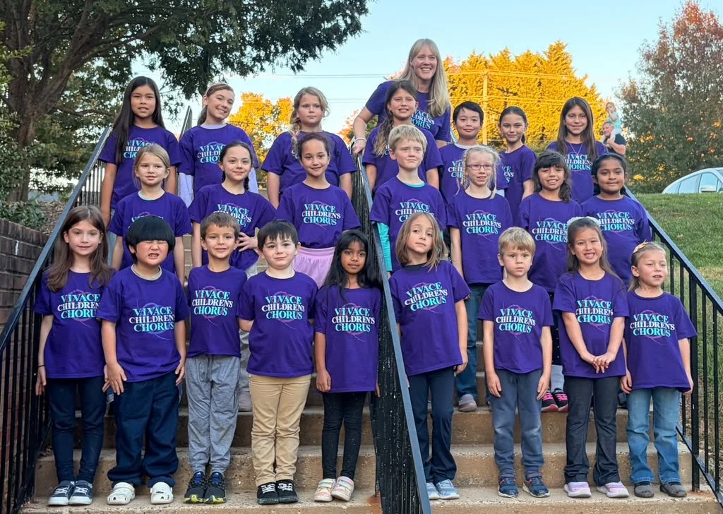 Vivace Children’s Chorus singers in purple Vivace t-shirts on the steps outside Ashton United Methodist Church with director Dr. Ingrid Lestrud.
