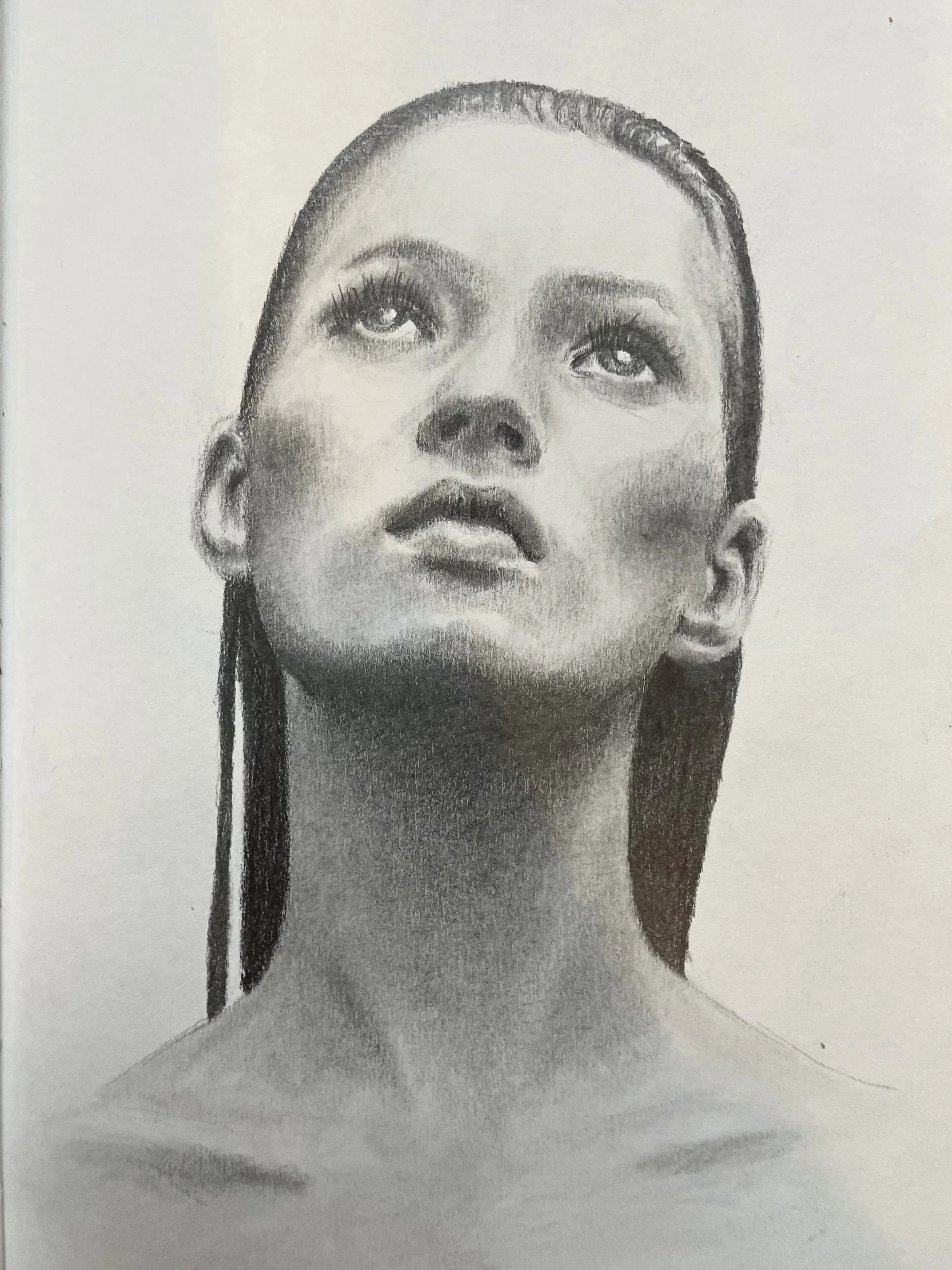 Pencil drawing of a woman with head slightly tilted upward, looking into the distance, with long straight hair and expressive eyes. Copyright Eloise Parker.