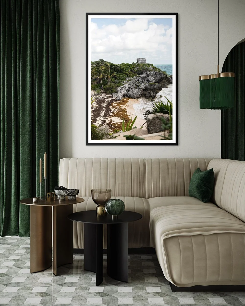 A living room with a beige couch, green curtains, a black chandelier, and a framed picture of a rocky beach with greenery and historical ruins on the wall.
