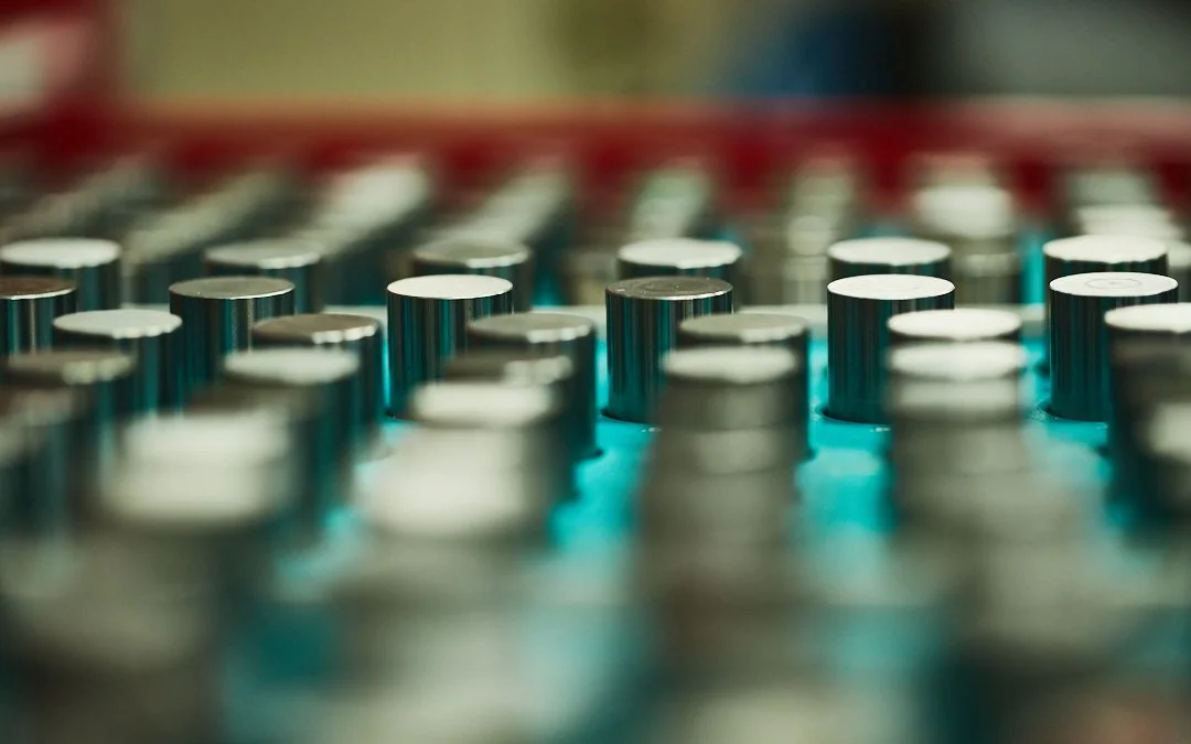 Close-up of metallic knobs on an audio mixing console with blue lighting.