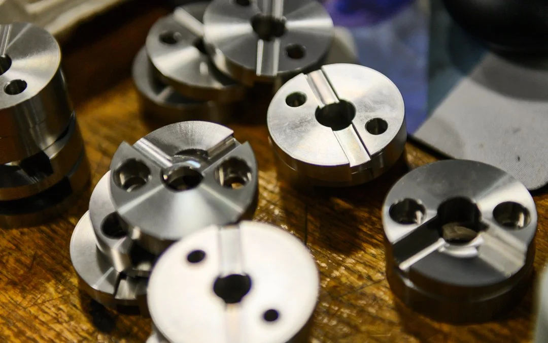 Multiple metal lathe collets arranged on a wooden workbench.