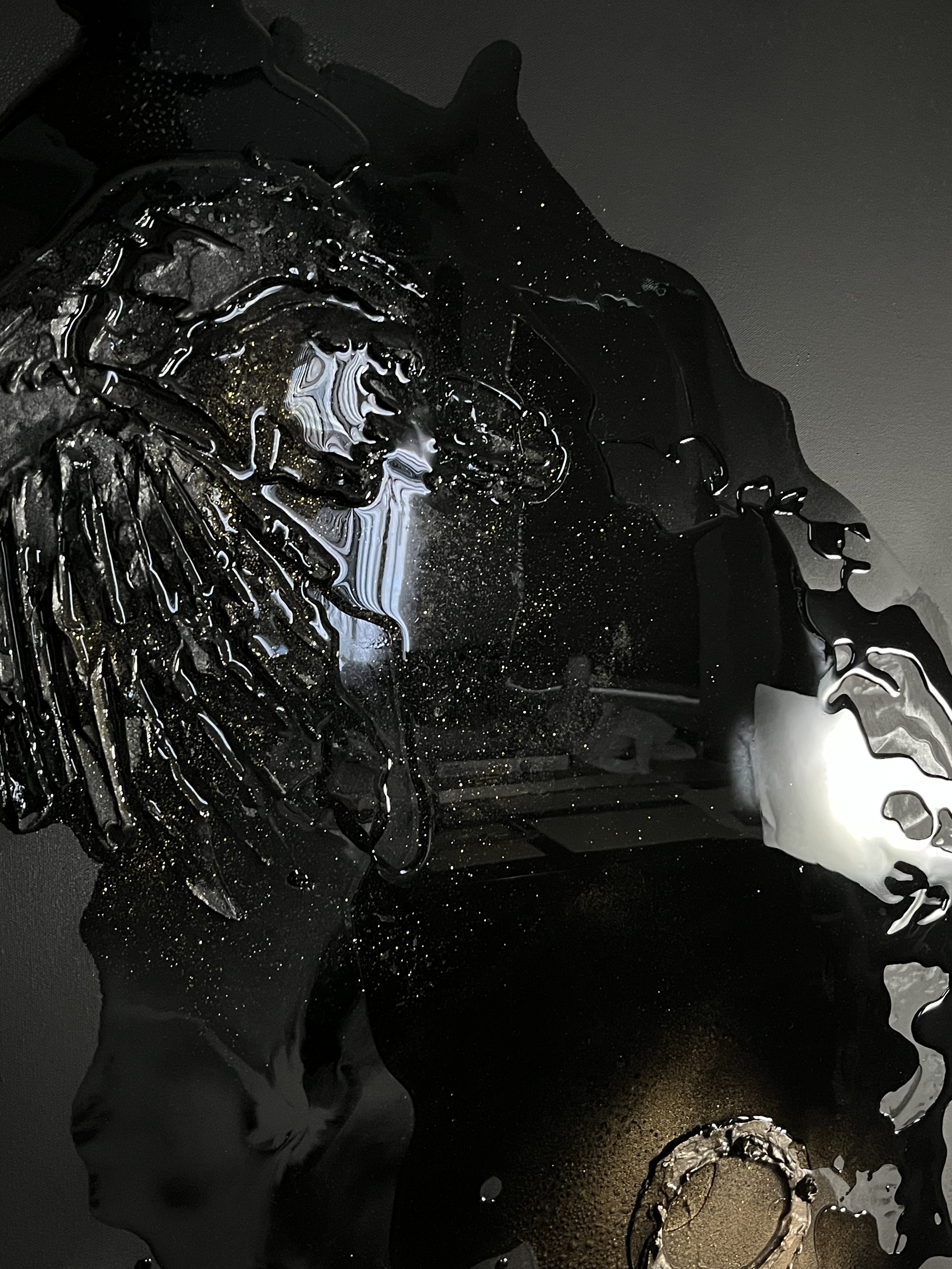 Abstract black and white art with shiny, textured surface and metallic accents.