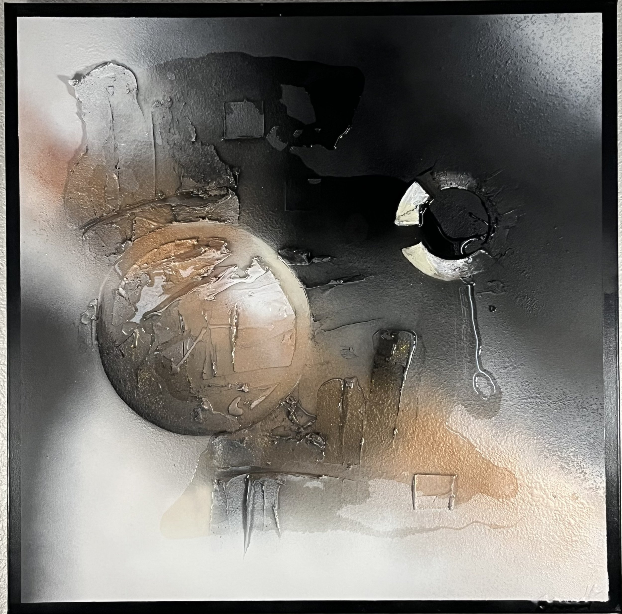 Close-up of a black metallic surface with visible holes and damage, including a circular cutout and scratched areas.