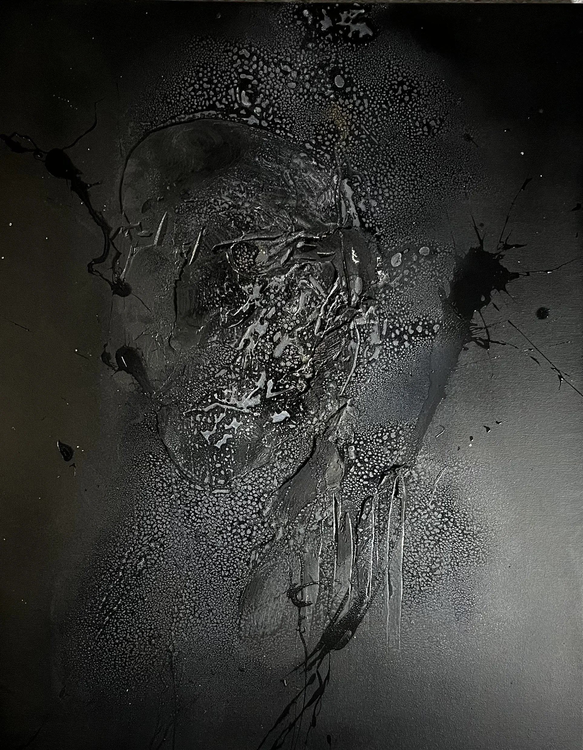 Abstract black and gray art with splatters and textured patterns.