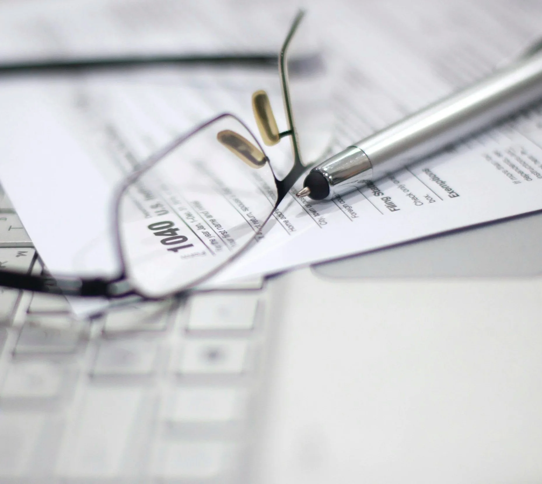 Tax preparation documents for NC CPA with pen and calculator