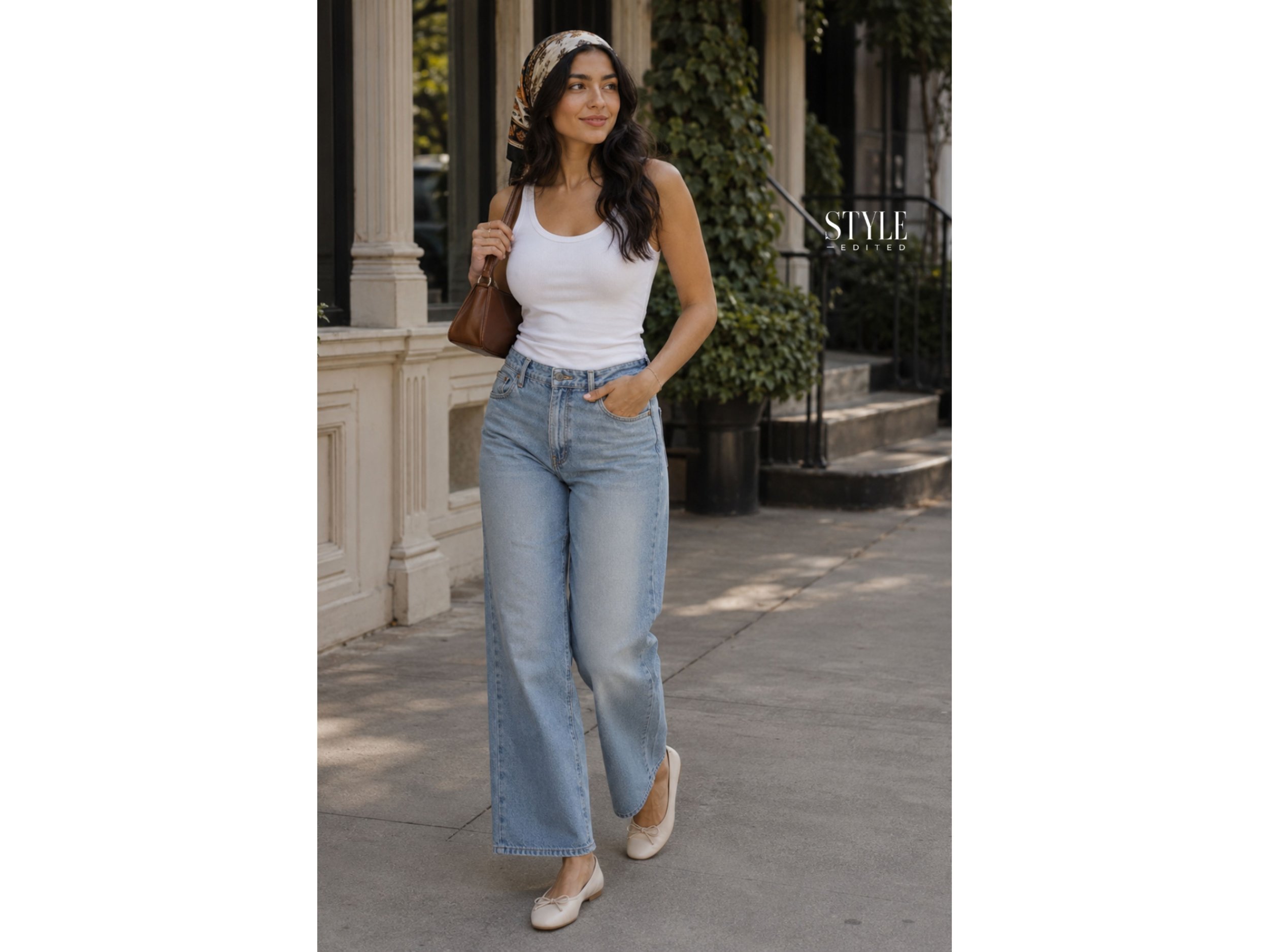Latina woman wearing a white tank with relaxed jeans, a printed head scarf, ballet flats, and a brown shoulder bag.