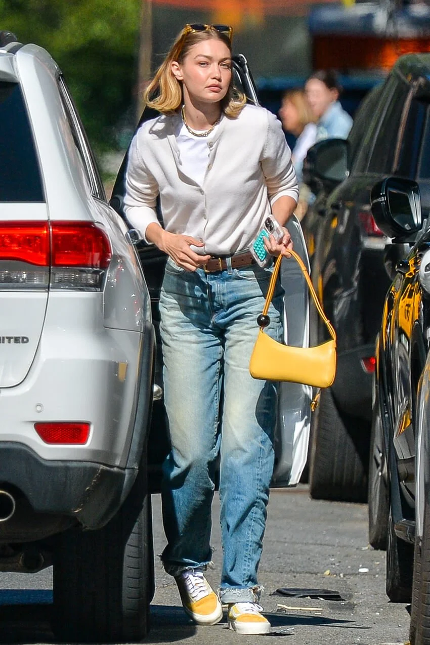 Gigi Hadid wearing yellow sneakers with straight-leg jeans, white tee, and light cardigan