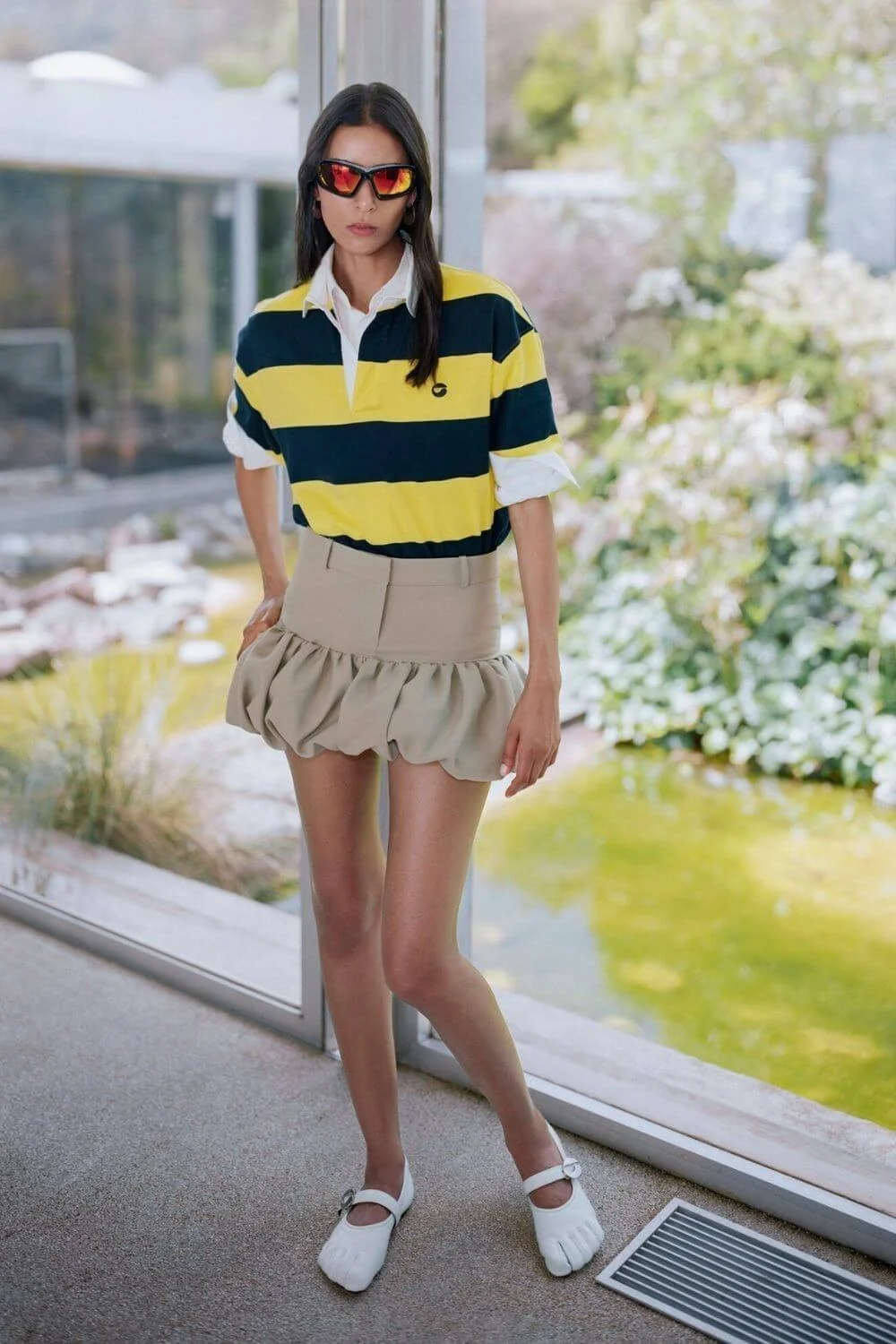 Striped contrast-collar knit polo styled with a bubble mini skirt and flats