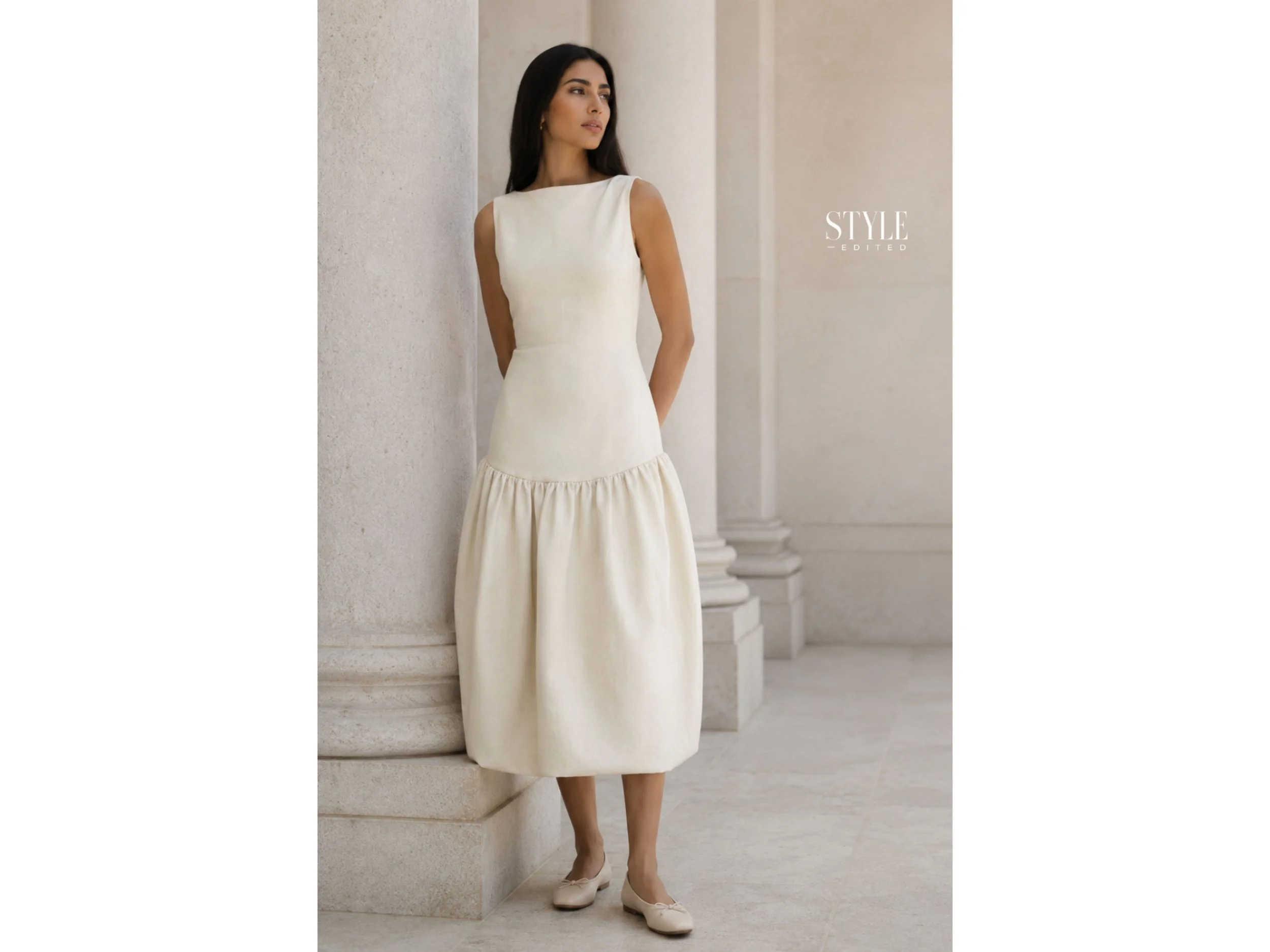 Middle Eastern woman wearing a cream drop-waist dress with ballet flats in an elegant colonnade.