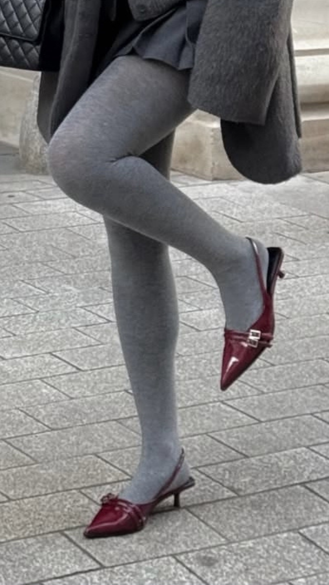 Burgundy slingback kitten heels styled with grey tights for a chic monochrome off-duty outfit.