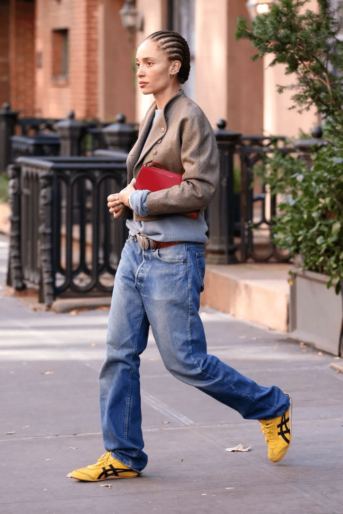 Dua Lipa wearing yellow Onitsuka sneakers with loose jeans and blazer