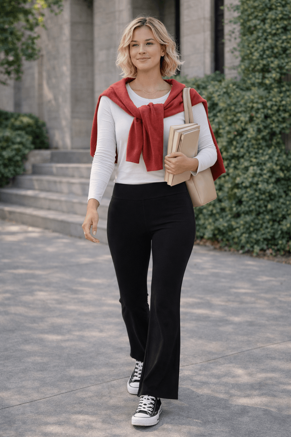 Black flare leggings styled with a fitted white long-sleeve tee, red sweater draped over the shoulders, and black platform Converse for a casual, put-together outfit