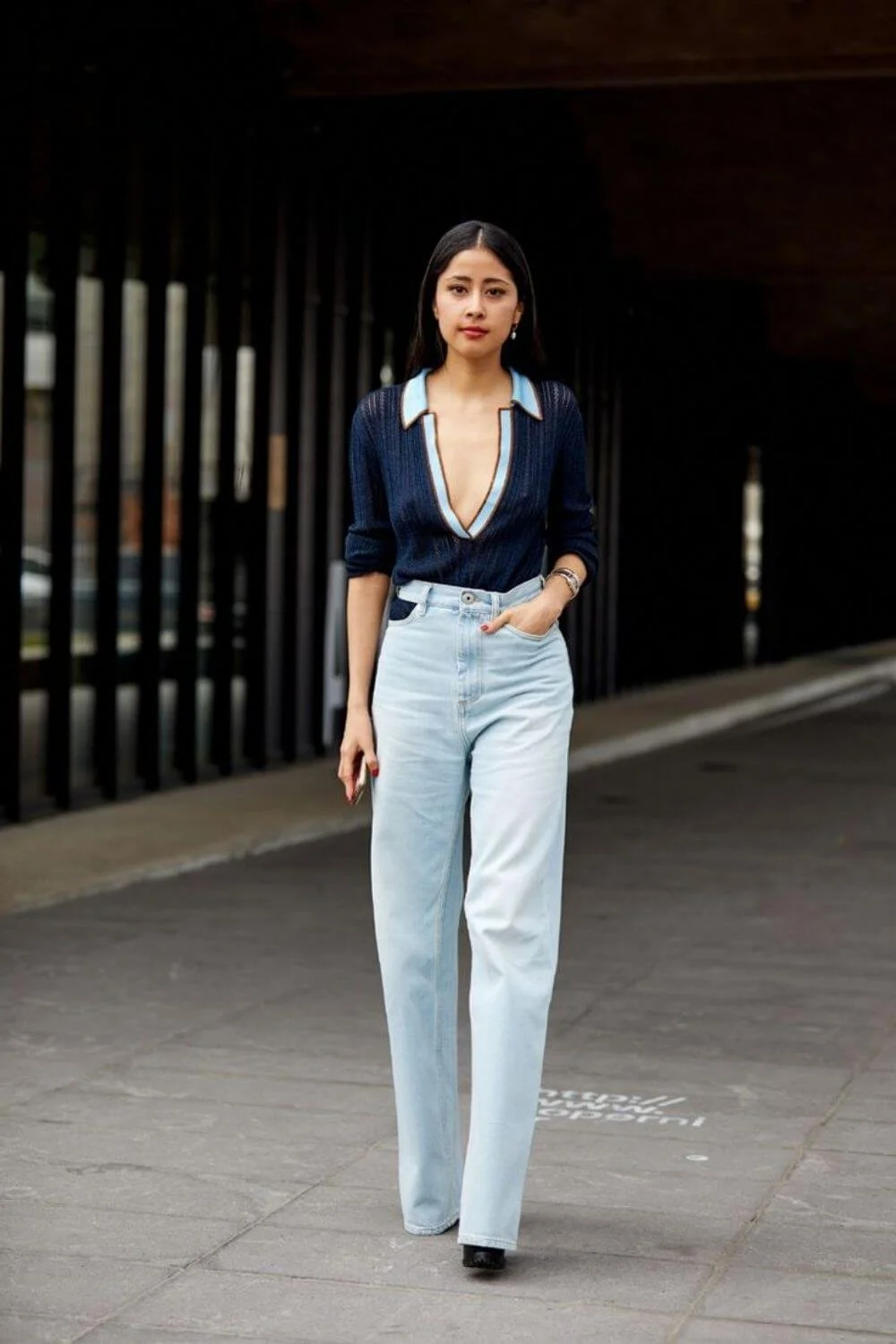 Deep V knit polo styled with light straight-leg jeans and minimal accessories