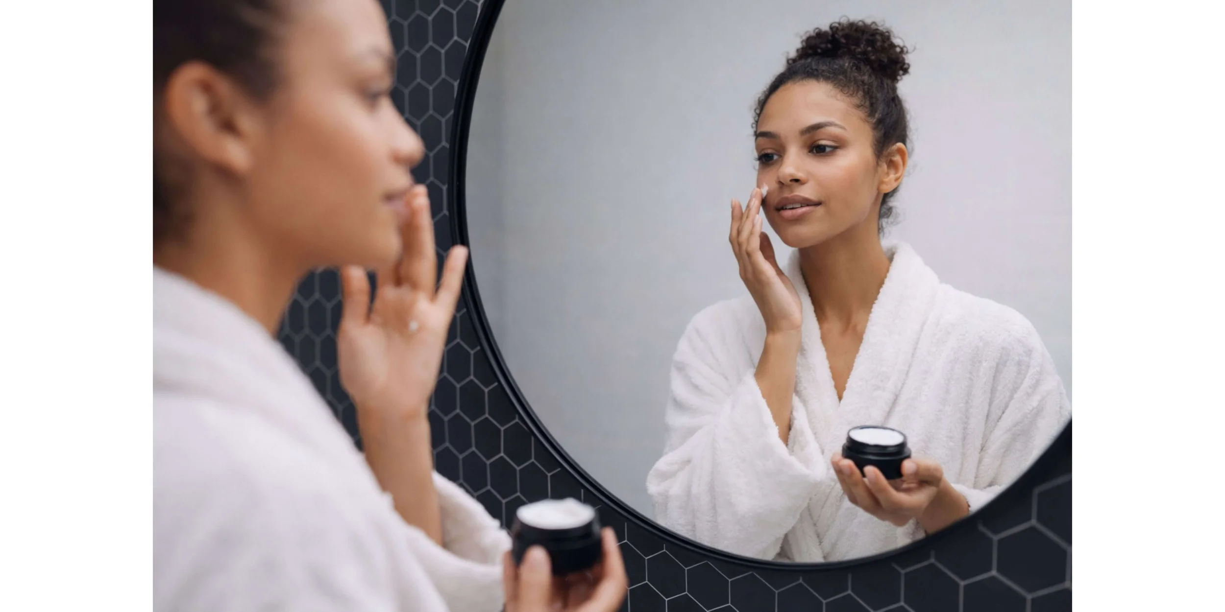 Woman with fair skin gently applying moisturizer to cheek before makeup