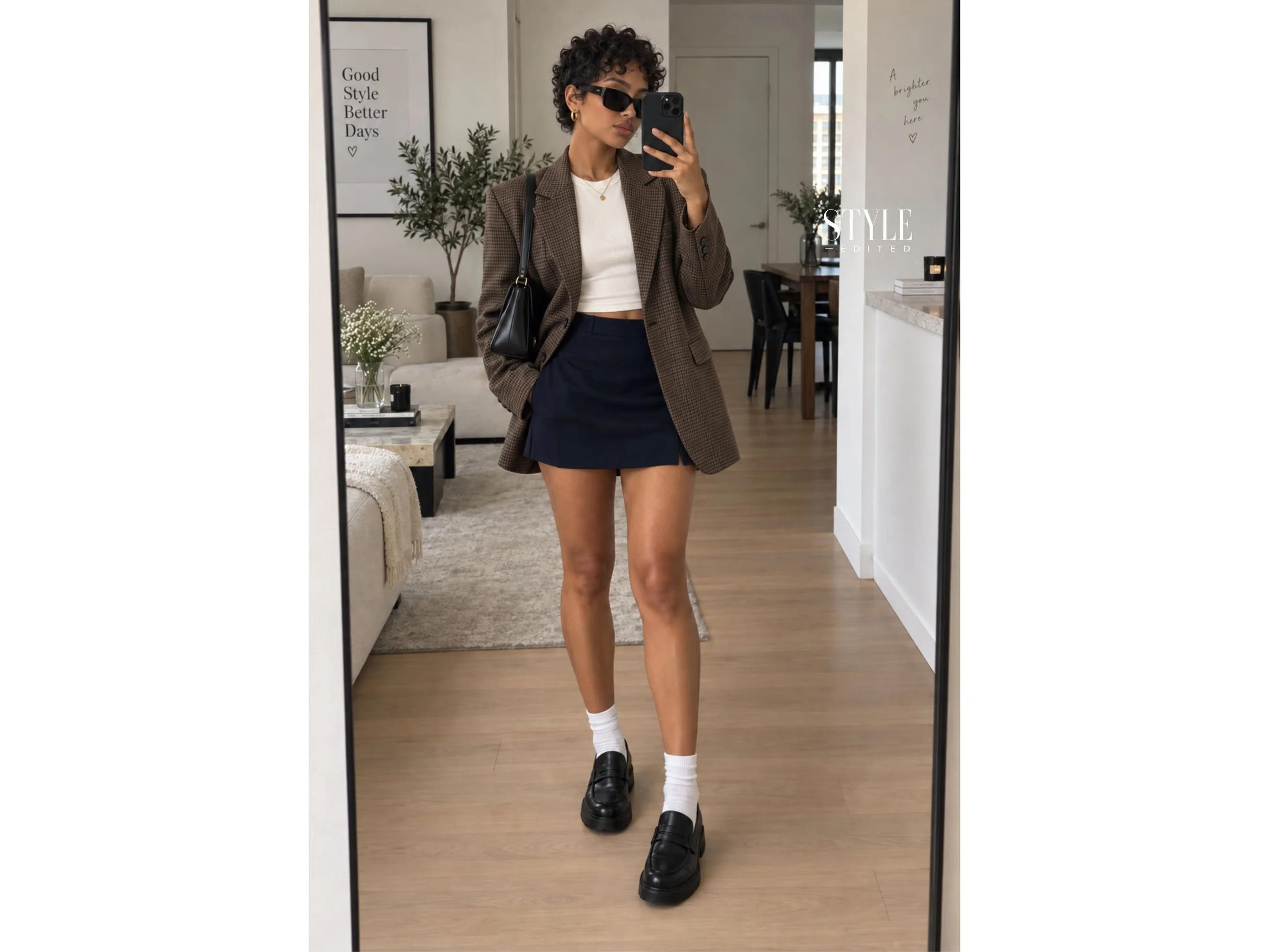 Mirror selfie of a petite Afro-Latina woman in a brown check blazer, ivory tee, navy mini skirt, white socks, and black loafers.