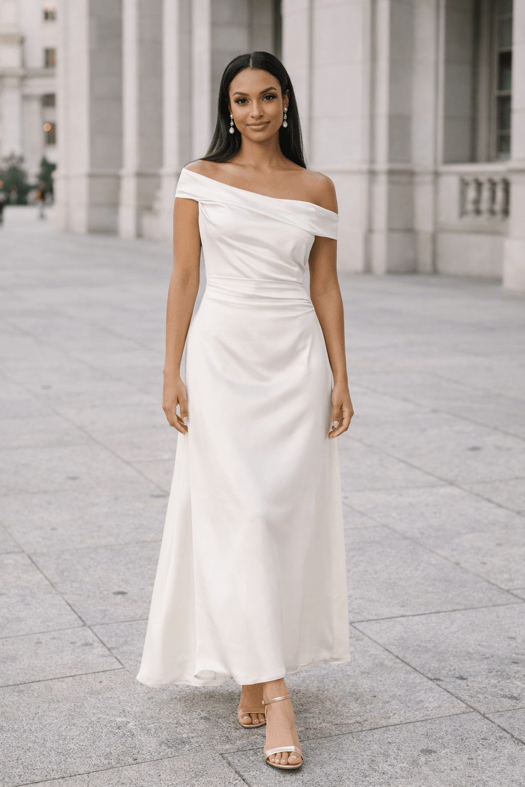 Bride wearing off shoulder satin A line elopement dress standing in courthouse plaza with relaxed posture