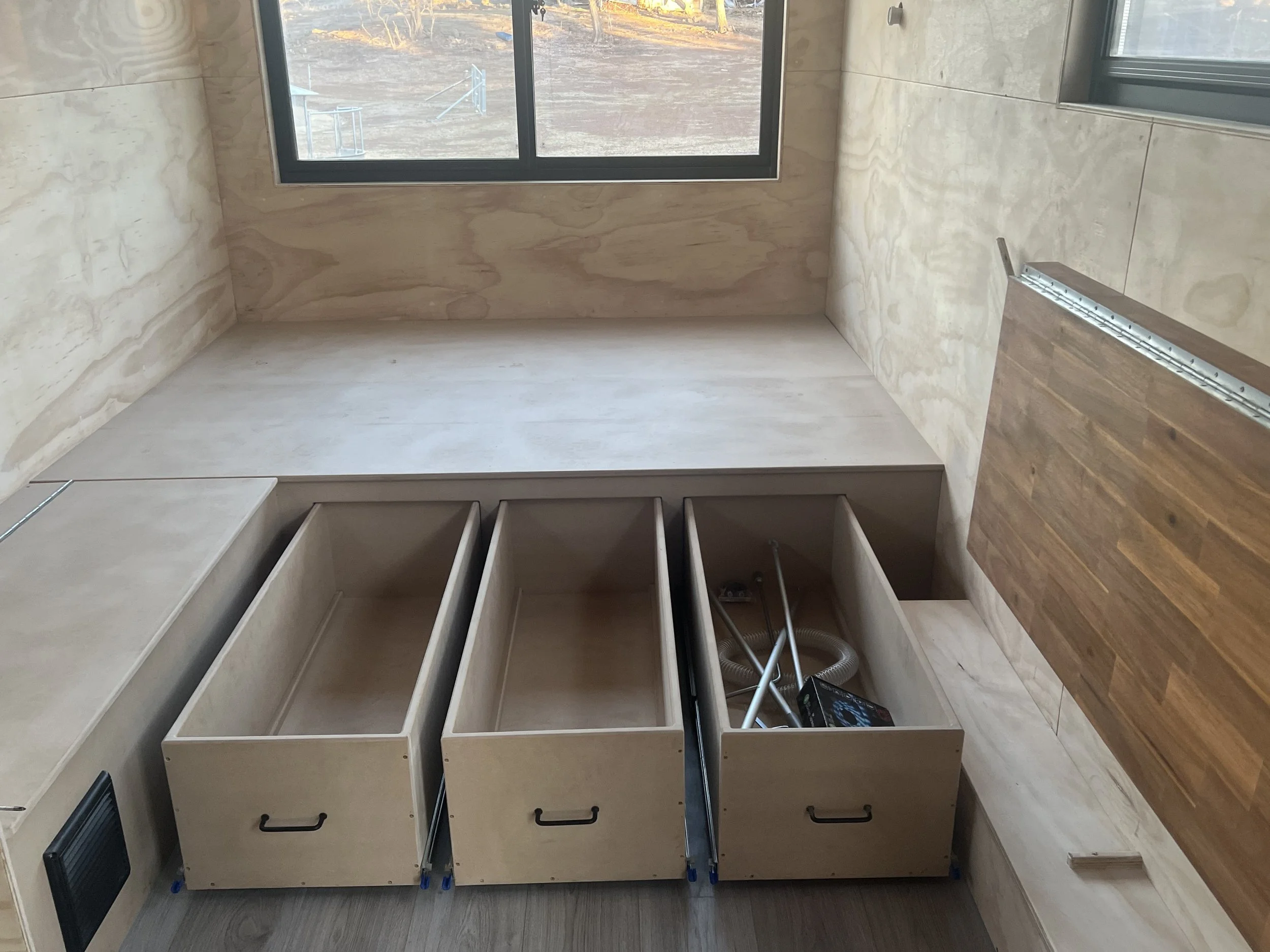 Custom bed base with open drawers, vacuum tubes and other tools.