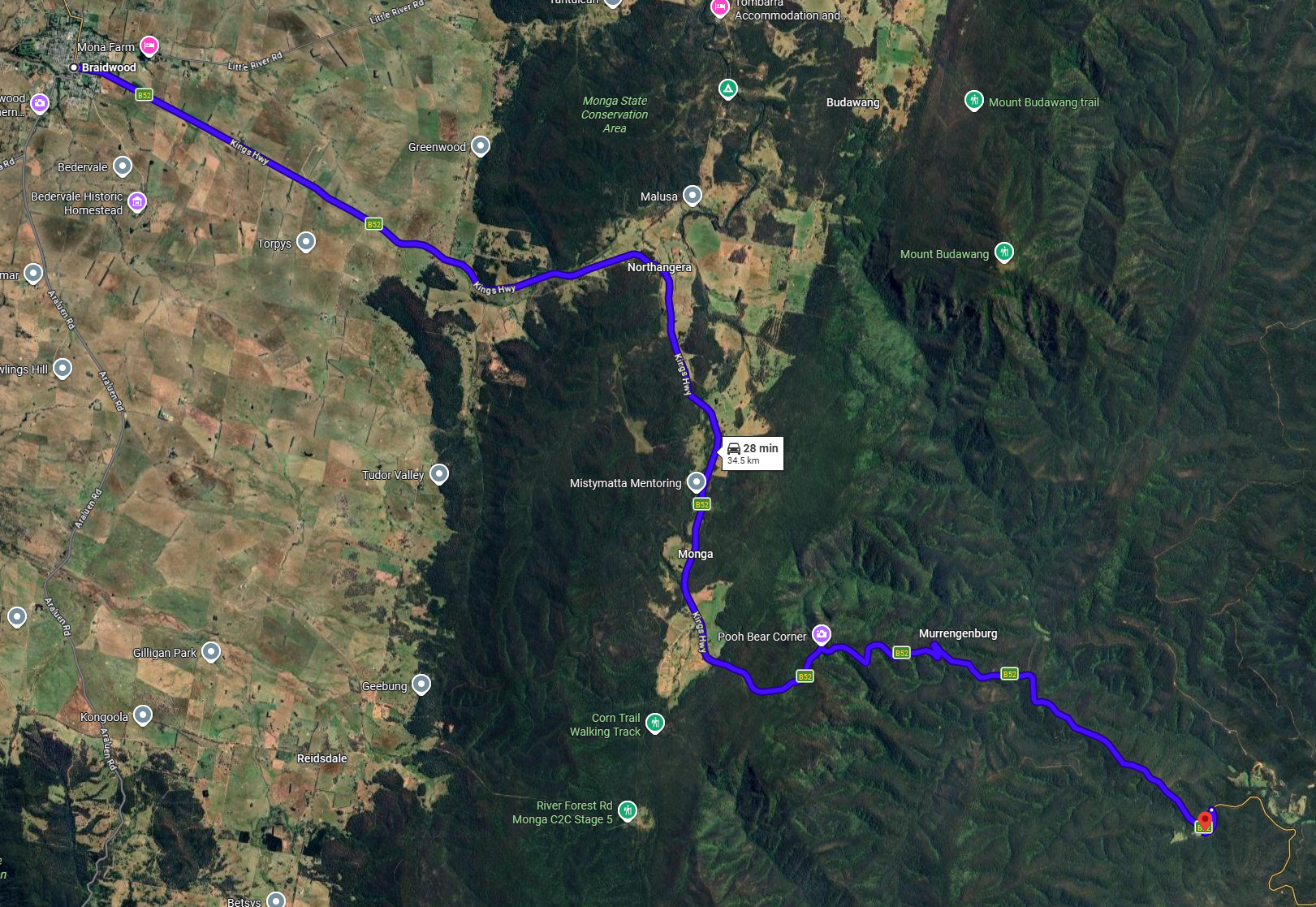 Satellite map of a route through a rural and forested area, with landmarks labeled including Pooh Bear Corner, Monga, Northanger, and Braidwood, showing a driving route of about 34.5 km taking approximately 28 minutes.