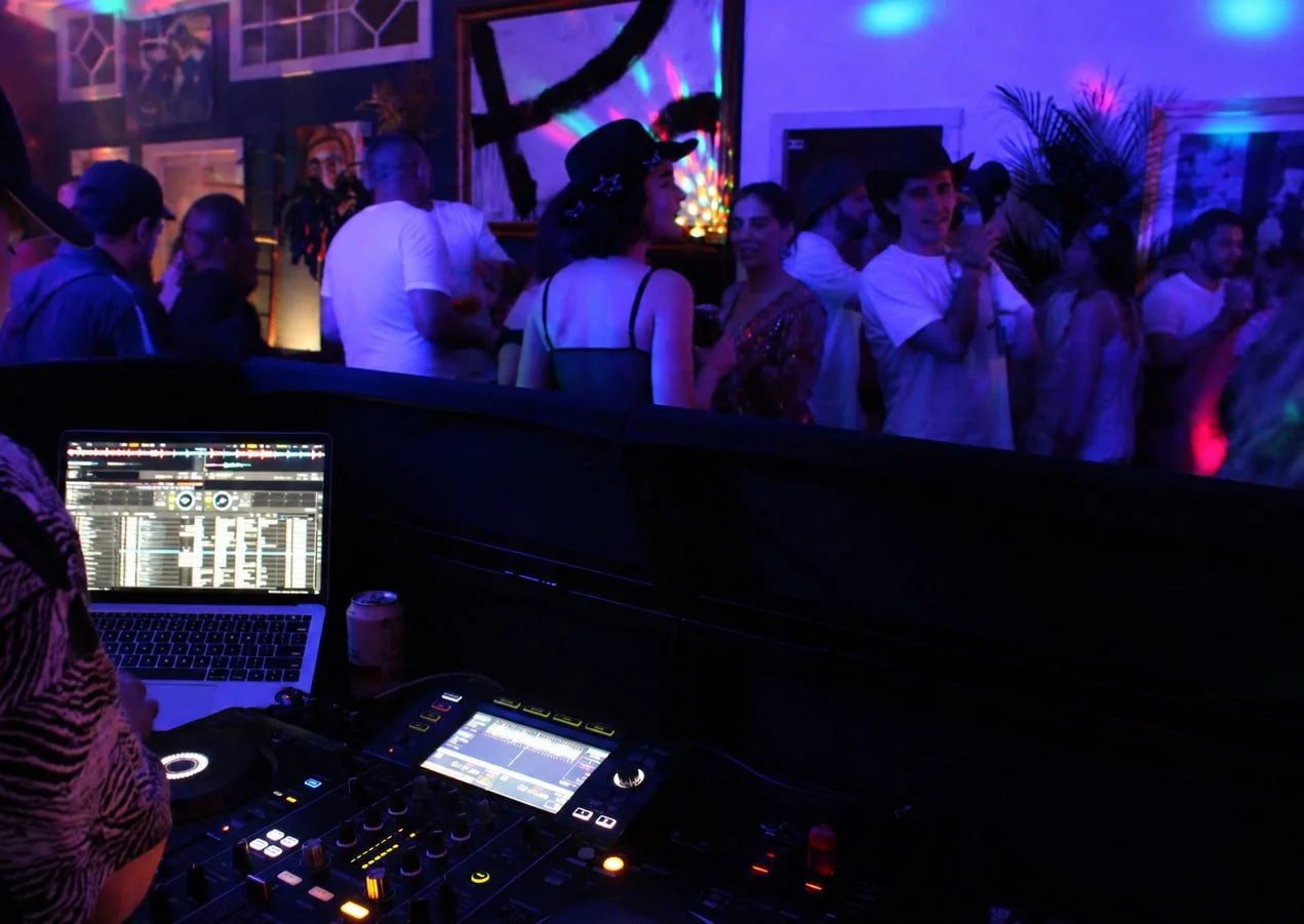 View from the DJ booth over a crowd dancing at a 30th birthday party