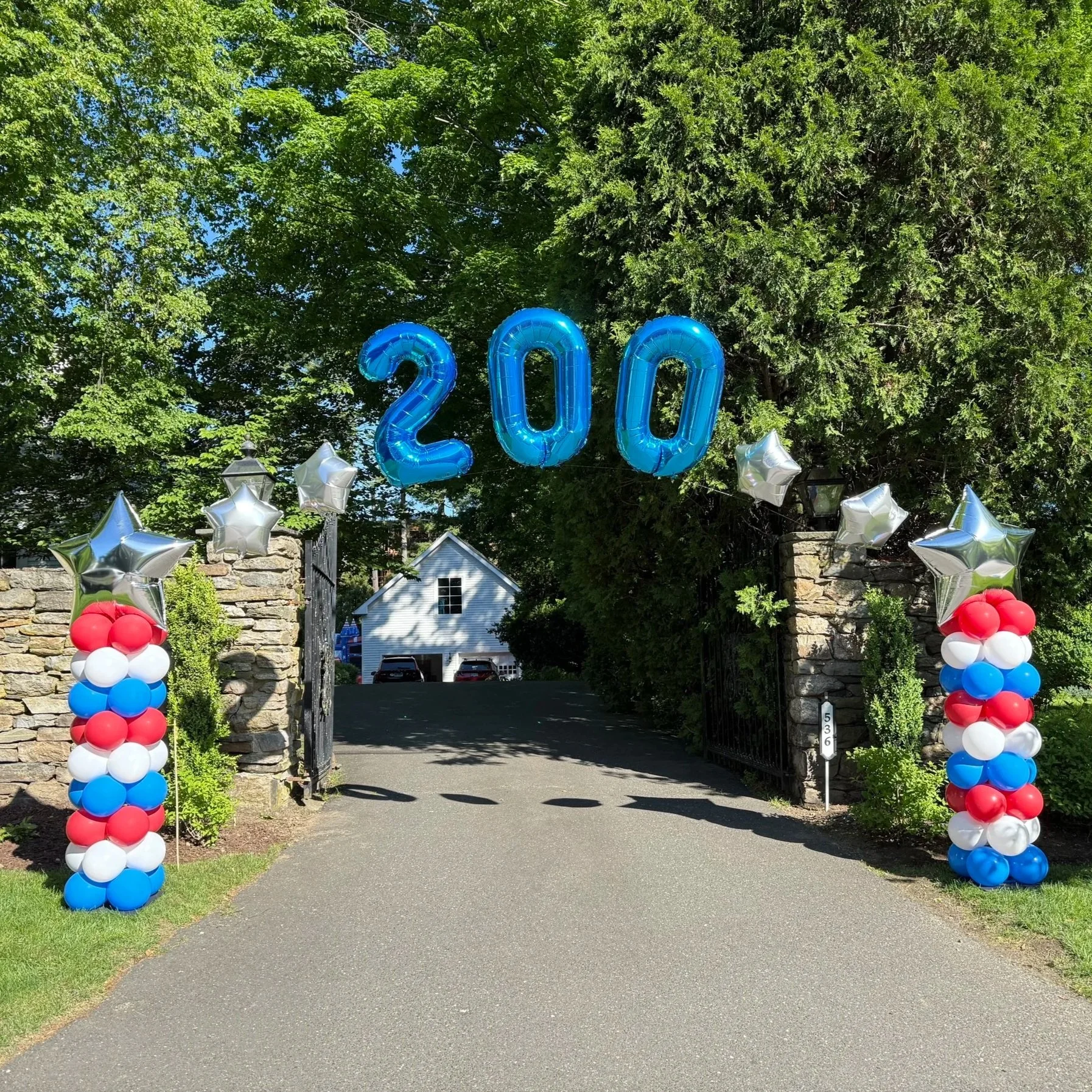 Red white and blue balloon columns with silver star tops and floating number balloons make a patriotic balloon display in Fairfield CT