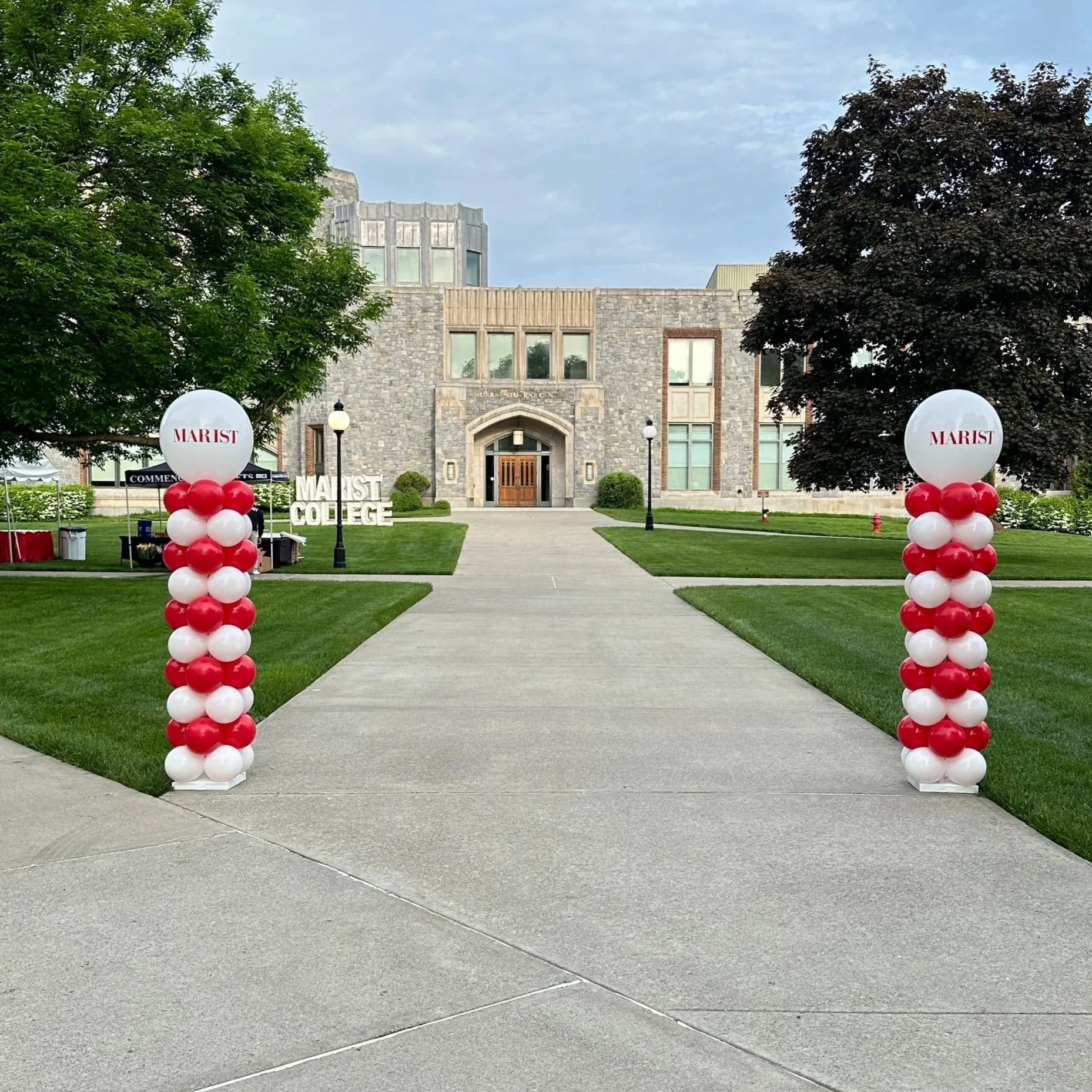Balloon columns in red and white with white round toppers for graduation at Marist University.