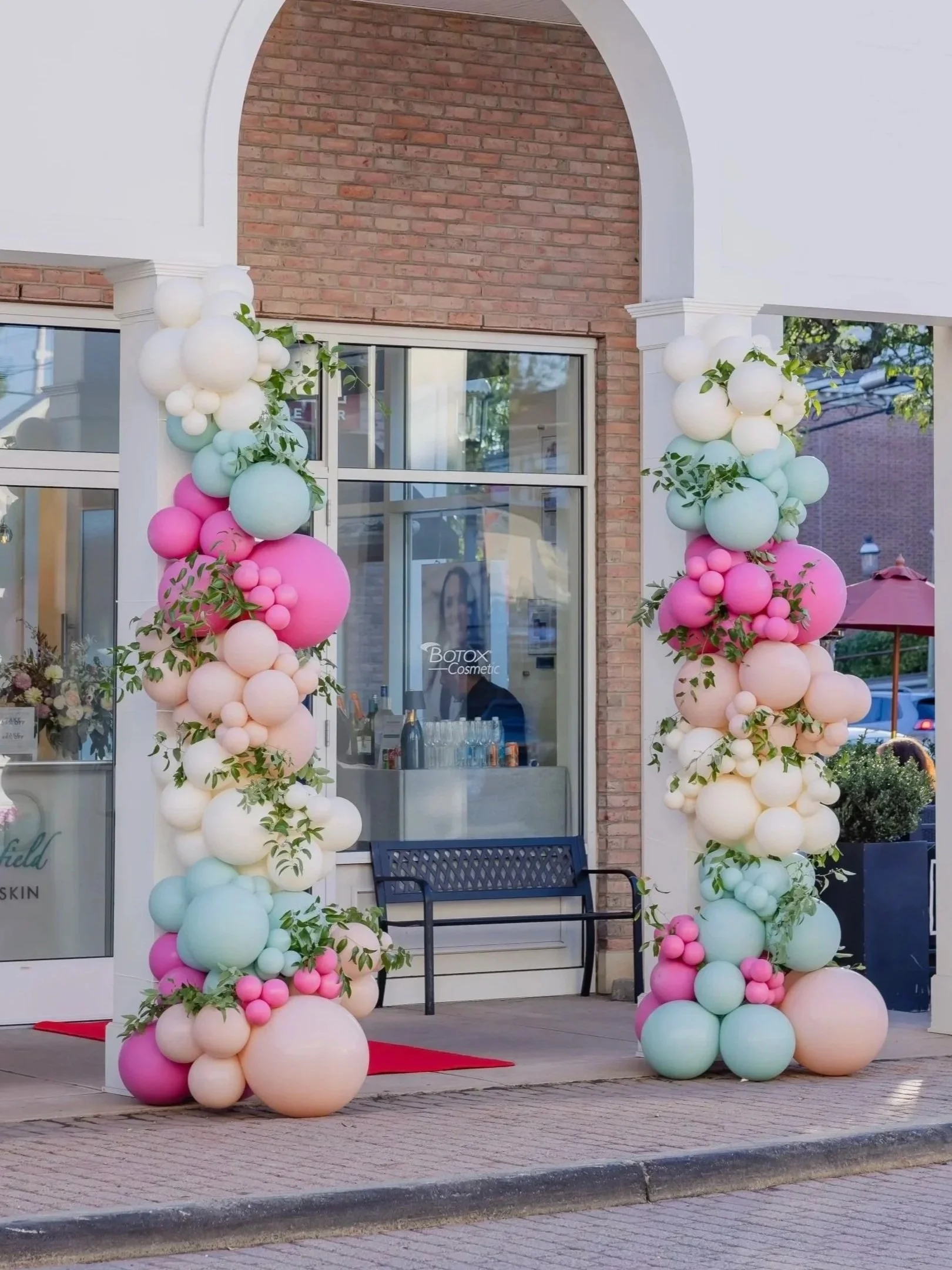 Balloon installation in pink, green and neutral balloon with real greenery incorporated outside Fairfield local business Nichols MD, located in the Brickwalk in Fairfield CT.
