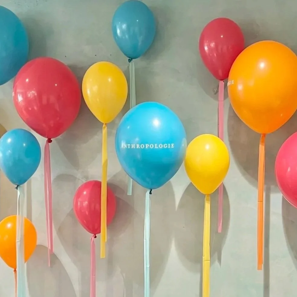 Helium balloons in birght colors with Anthropologie logos for launch of new dresses