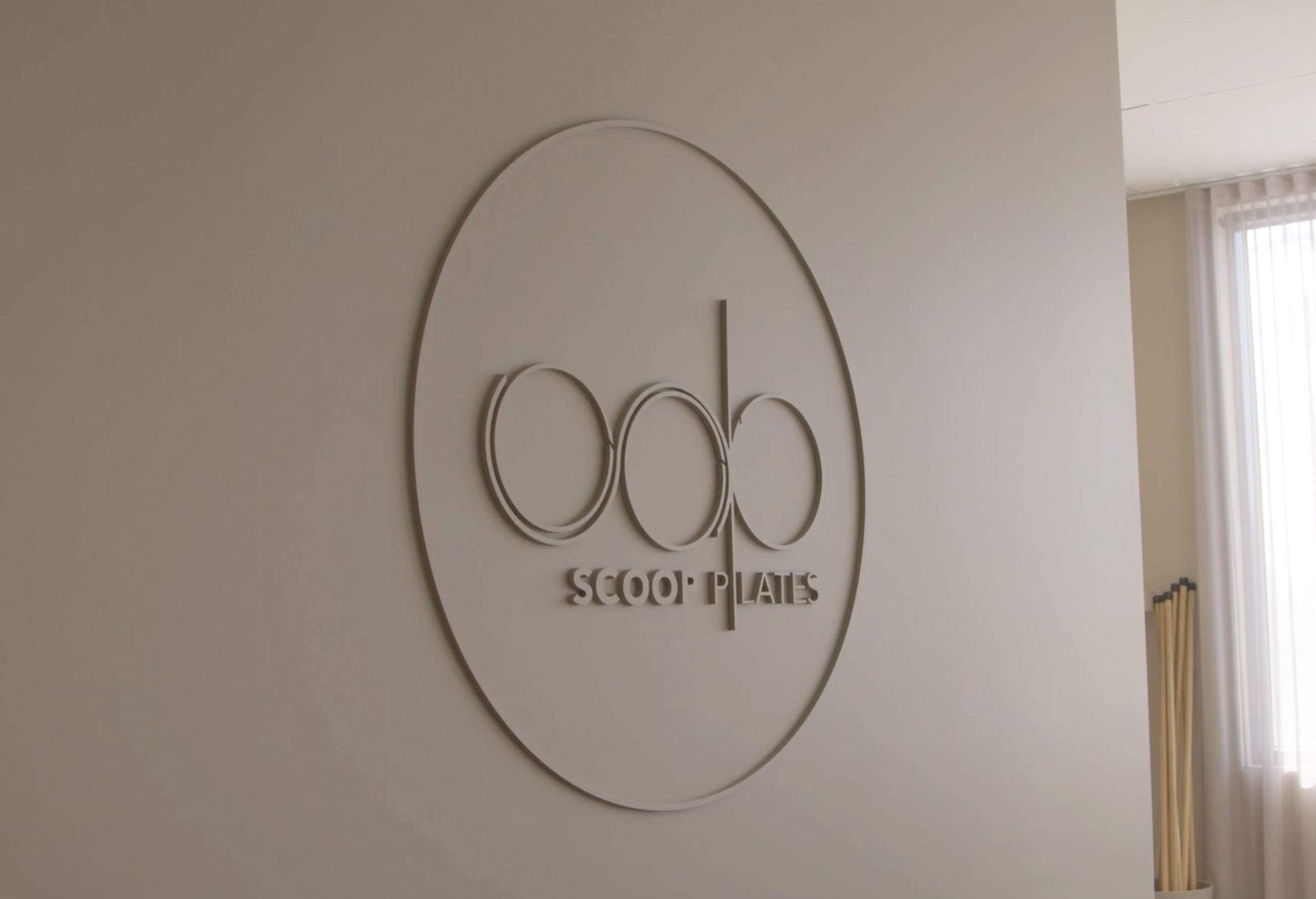 Sign on the wall with the logo and text 'Scoo Plates'