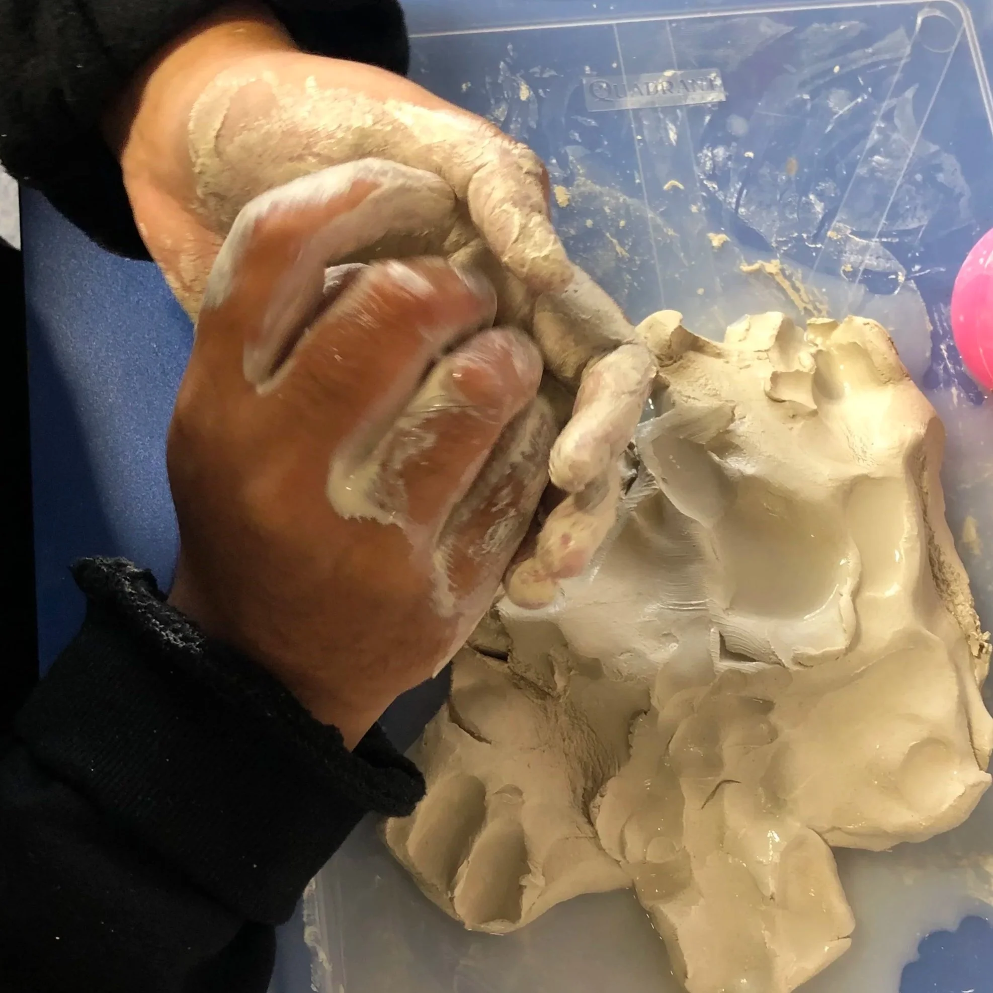 hands working with wet clay