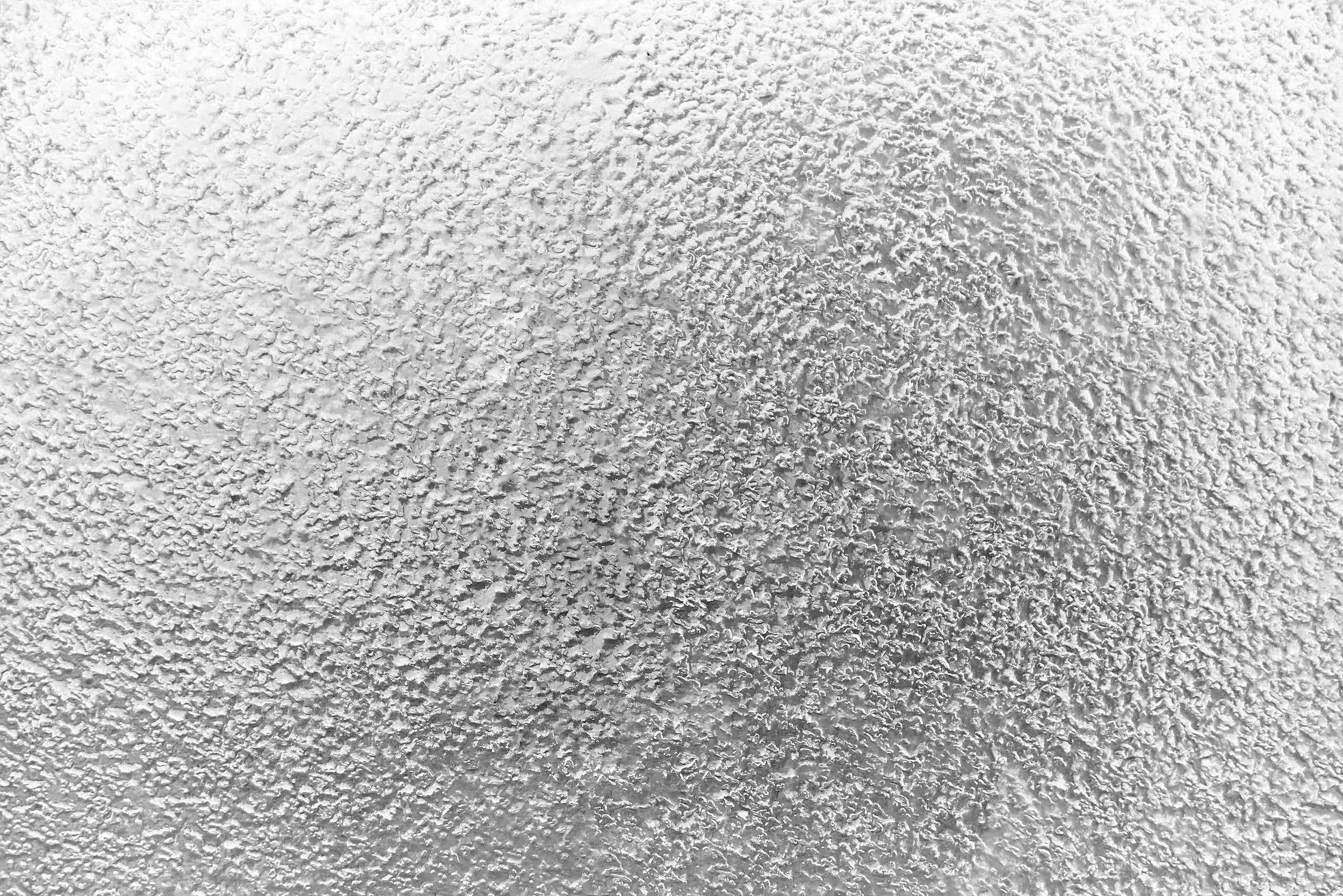 Close-up of a textured white wall surface.