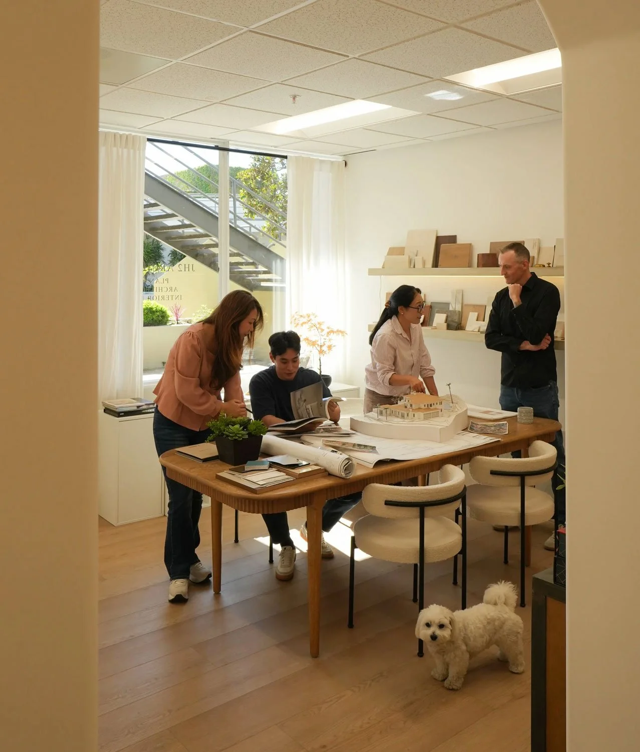 JH2 Architects Team analyzing a model home on a desk in their main office room
